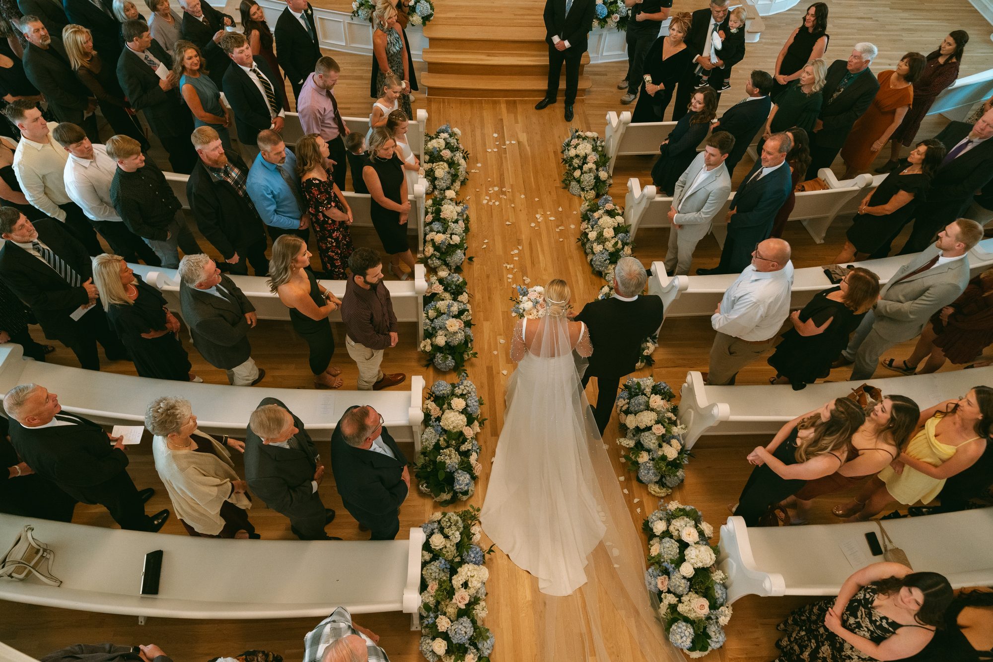 Wedding ceremony beneath the original stained glass at Melrose Abbey, a 1922 Gothic church in Kansas City